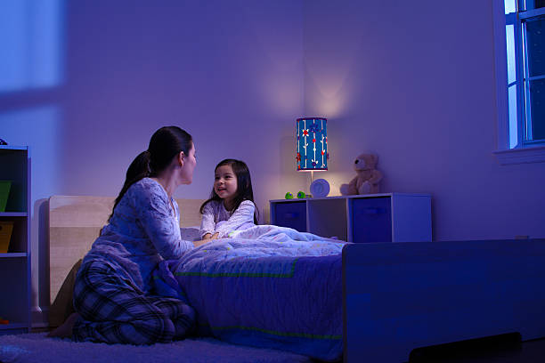 Maman pendant le rituel du coucher avec sa fille pour éviter les troubles du sommeil