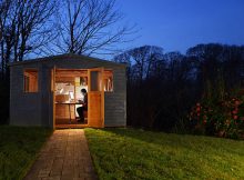 Abri de jardin en bois qui abrite une pièce supplémentaire transformée en bureau