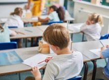 Salle de classe primaire avec élèves qui travaillent à leur bureau