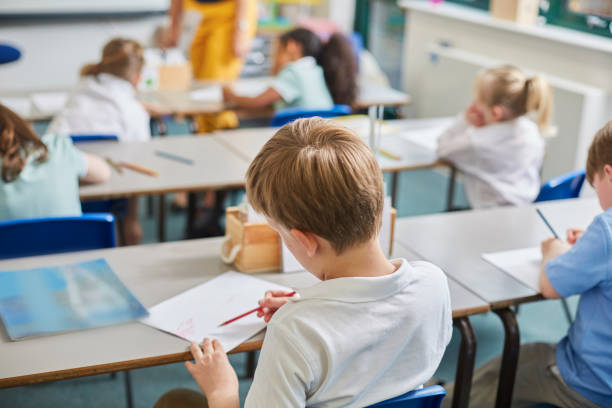 Salle de classe primaire avec élèves qui travaillent à leur bureau