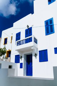 Maison style méditerranéen blanche et bleue, avec volets et portes peints en bleu vif