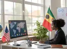 Jeune professionnel en visio-conférence dans un bureau moderne, avec des éléments multiculturels (drapeaux, cartes, globes) visibles.